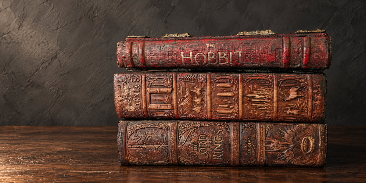The Hobbit, Narnia and The Lord of the Rings bindings stacked on dark walnut