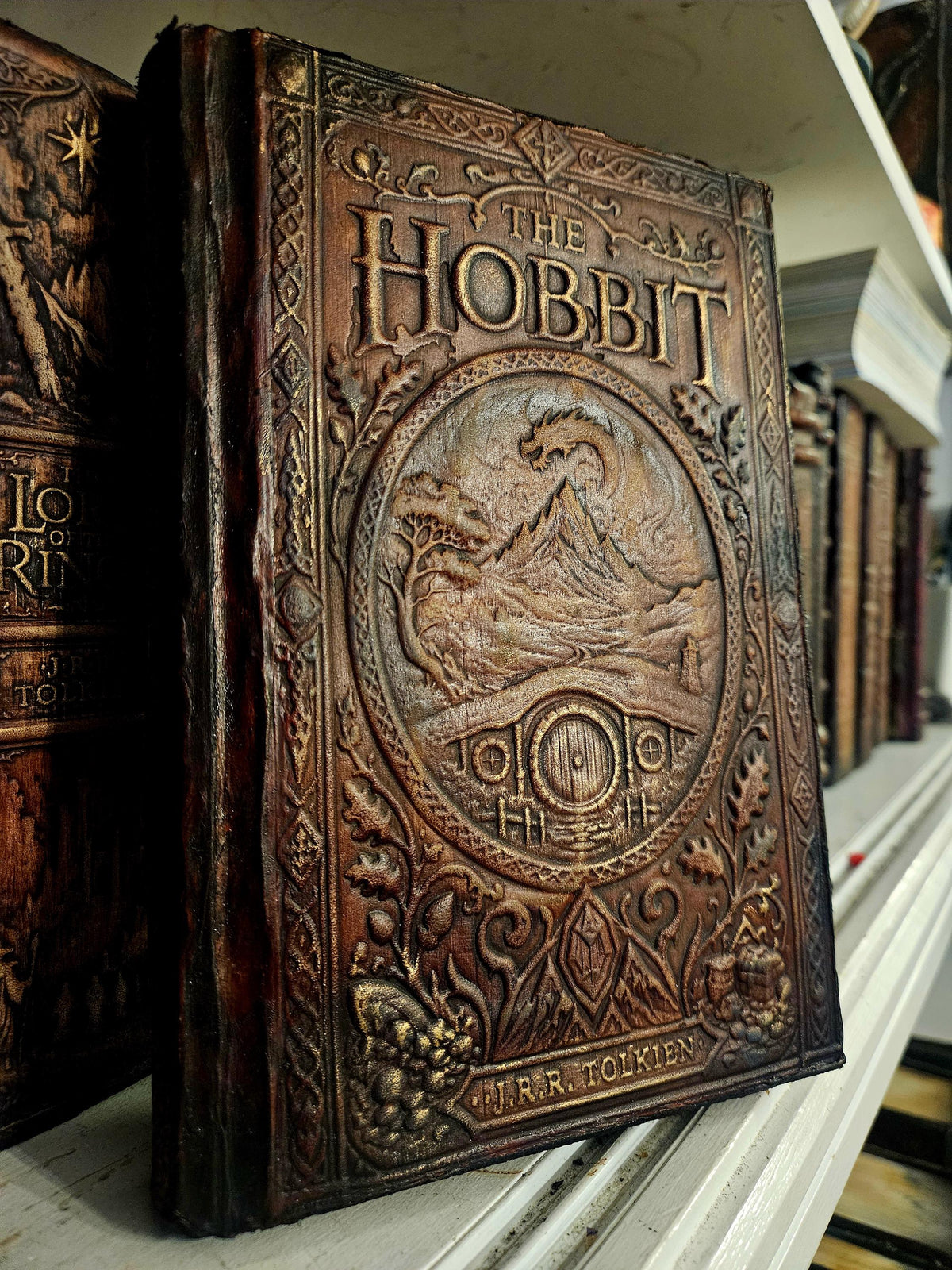 THE HOBBIT and Tolkien visible, original embossed mountain/dragon/hobbit door art; distinct red-eye binding. — original photograph, binding example